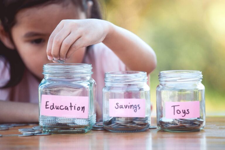 A kid putting money in jars for saving