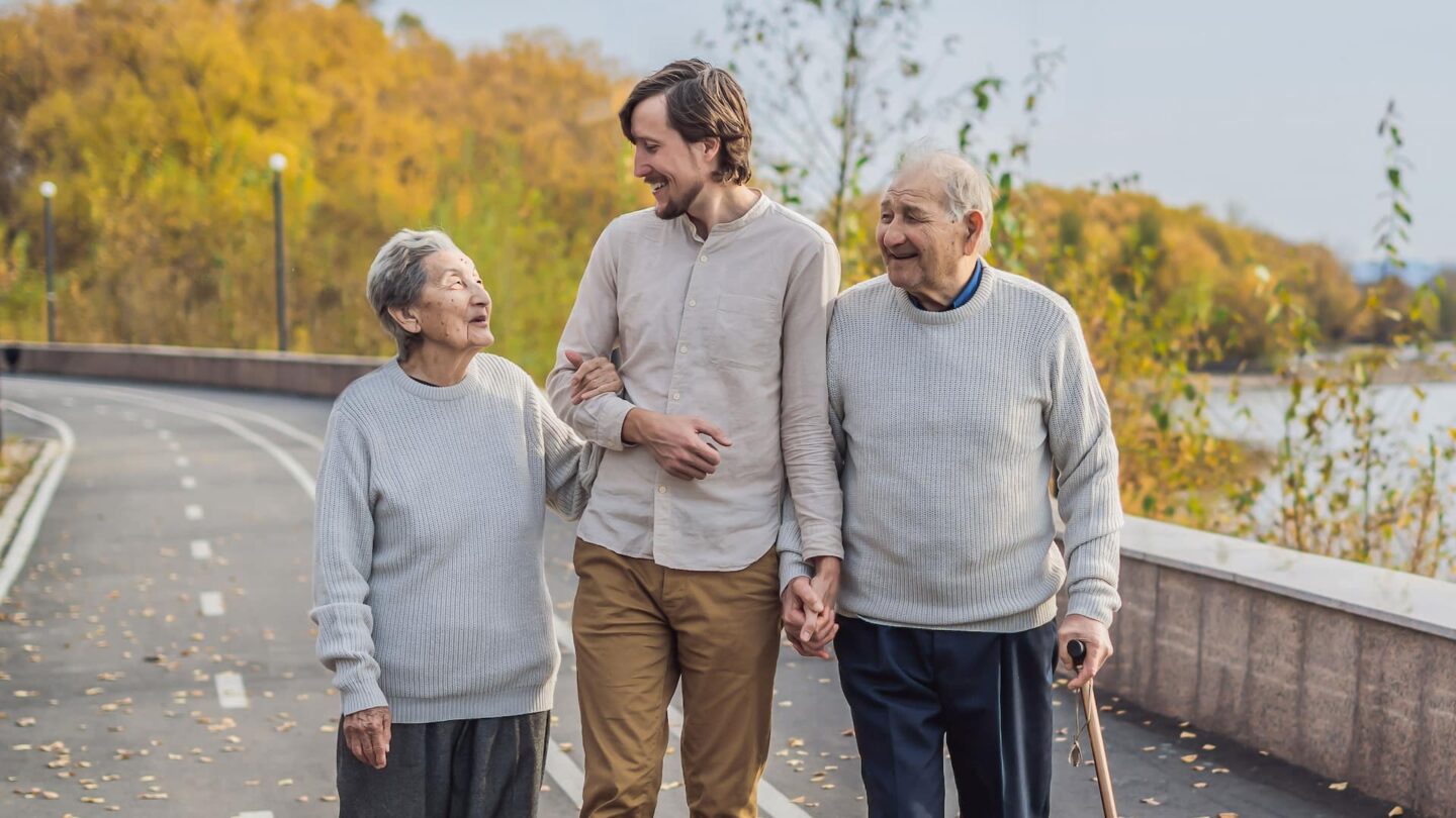 An elderly couple walking outside with their grandson