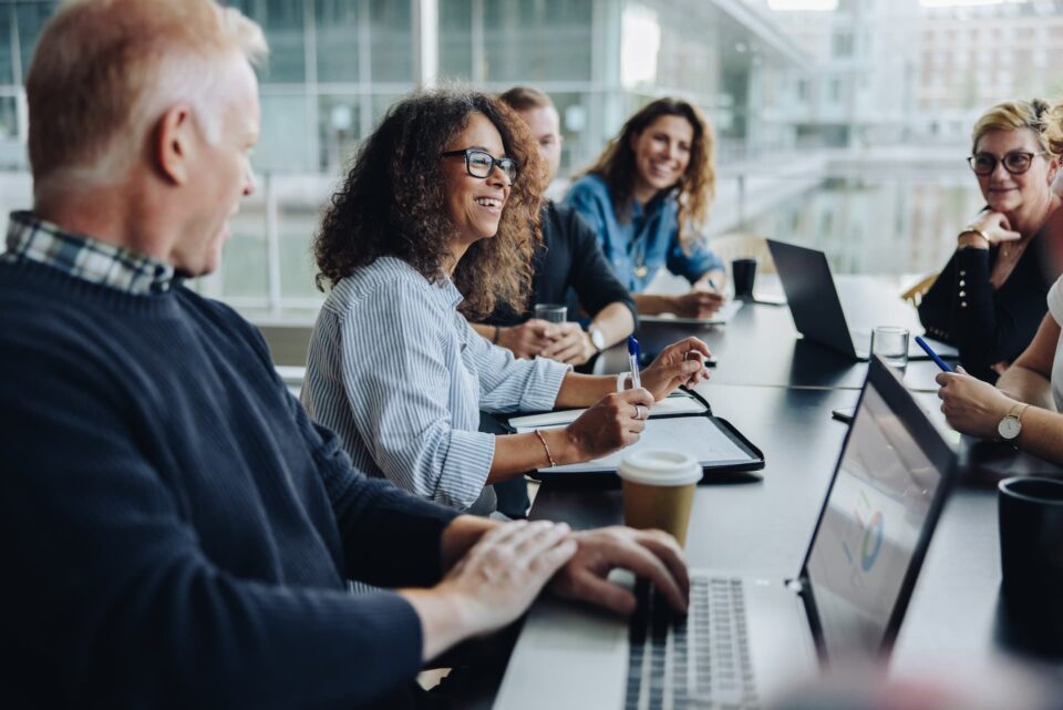 A group of business people sitting at a large conference table