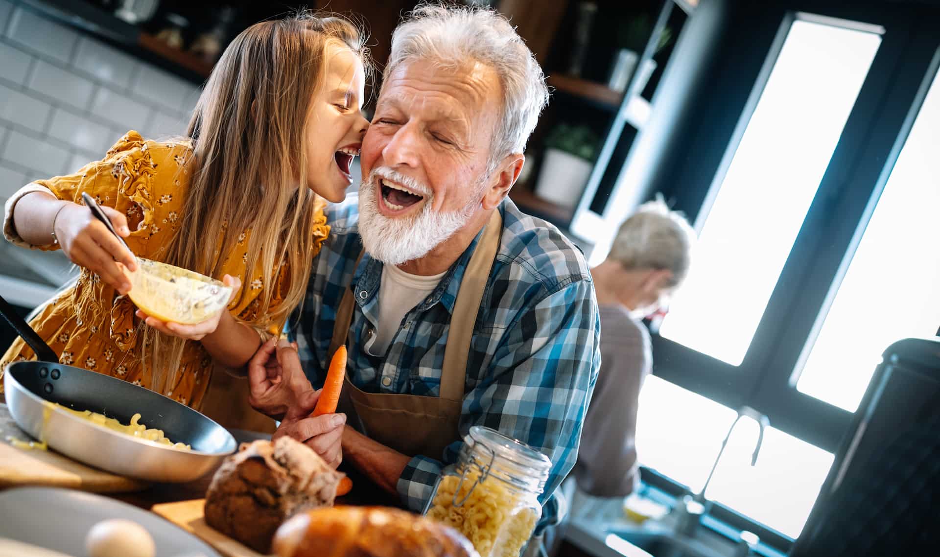 A grandfather cooking a meal with his grandaughter
