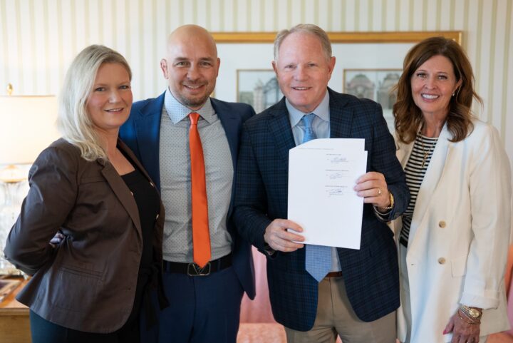 Lee-Ann Prickett, Jamie Prickett, Monte Holm, and Lisa Holm standing together after signing documents to officialize their alliance.